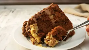 An easy German chocolate cake with yummy pecan & coconut frosting AND an amazing chocolate mousse cream surrounding it. But is it really German? Well, sort of!