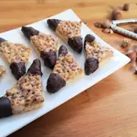 Nut corners recipe: Chocolate-dipped Nussecken with a buttery shortbread base, apricot jam layer, and caramelized nut topping—a perfect treat for year-round indulgence