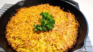 Kartoffelpuffer aus dem Ofen (baked German potato pancake casserole) baked in a cast-iron skillet with a crispy golden top and parsley garnish
