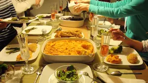 Family sharing a German dinner with several dishes served at the table