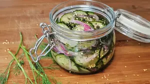 Quick German refrigerator pickles with red onion, dill, and mustard seeds in a glass jar