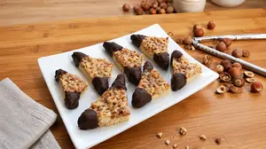 Nut corners recipe: Chocolate-dipped Nussecken with a buttery shortbread base, apricot jam layer, and caramelized nut topping—a perfect treat for year-round indulgence