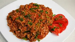 rice dinner with a side of tomatoes on white plate