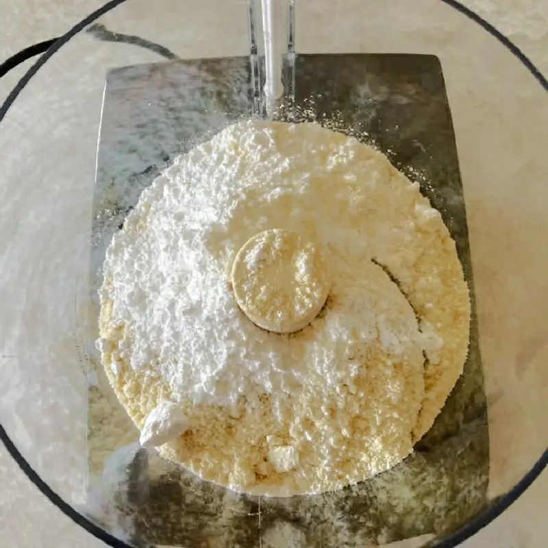 Almond flour and powdered sugar in a food processor for homemade German marzipan