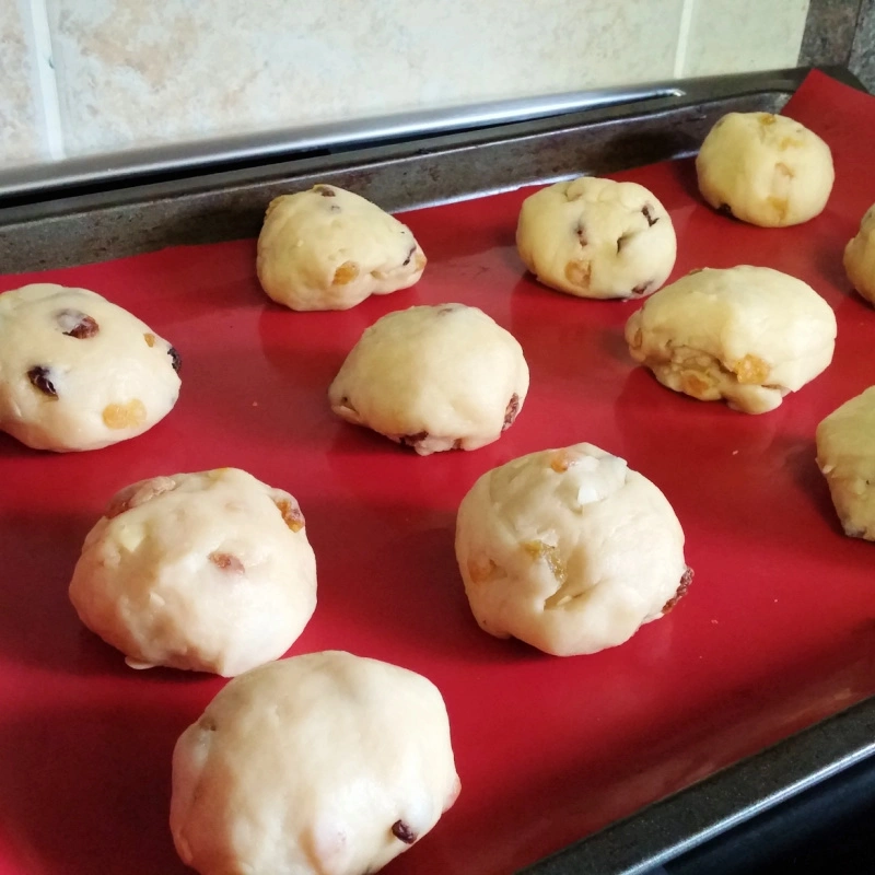 Unbaked Rosinenbrötchen dough balls resting on a baking sheet before rising