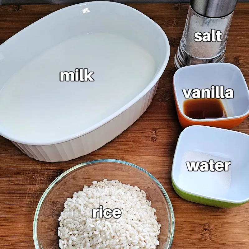 Ingredients for German Milchreis in a baking dish, including milk, short-grain rice, vanilla, and salt