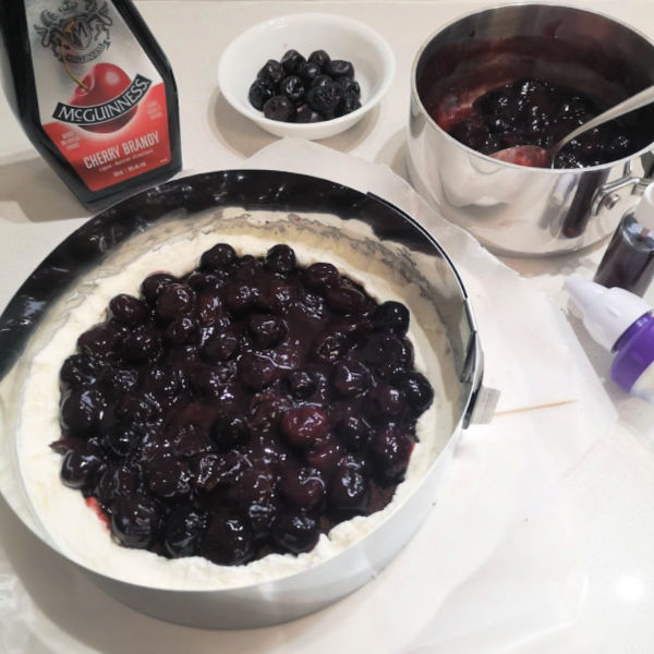 Start filling your Black Forest cake by piping a ring of whipped cream around the outside and filling with some cherry mixture Start filling your Black Forest cake by piping a ring of whipped cream around the outside and filling with some cherry mixture