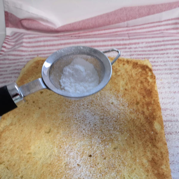 Sprinkle powdered sugar on the cake to keep it from sticking to the towel.