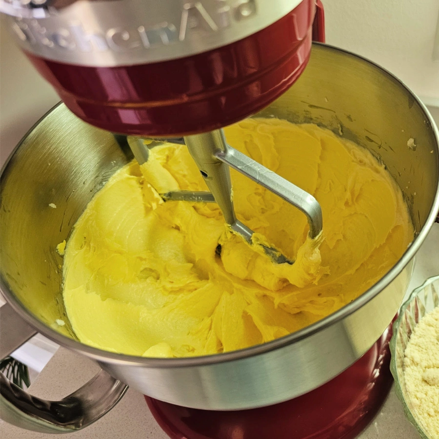 adding eggs to creamed butter and eggs for poppy seed cake recipe