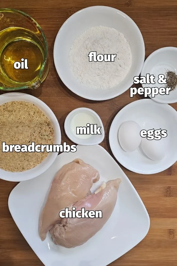 Chicken schnitzel ingredients with chicken breasts, flour, eggs, milk, breadcrumbs, oil, salt and pepper