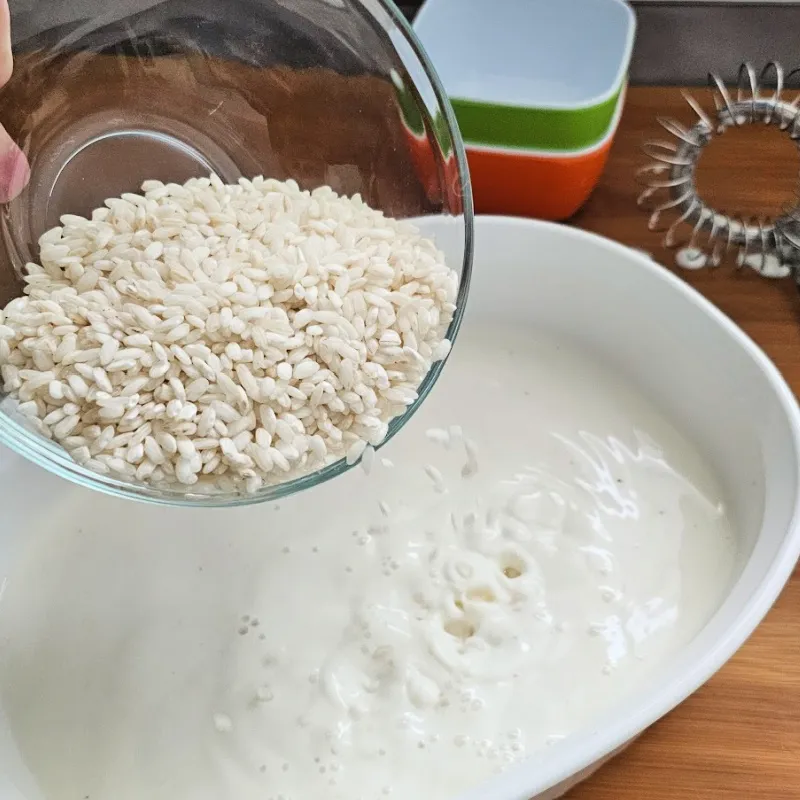 Short-grain rice being added to milk for oven-baked German Milchreis