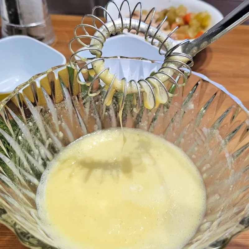 Whisking eggs and flour with water to make a thin batter for German egg drop soup (Einlaufsuppe).