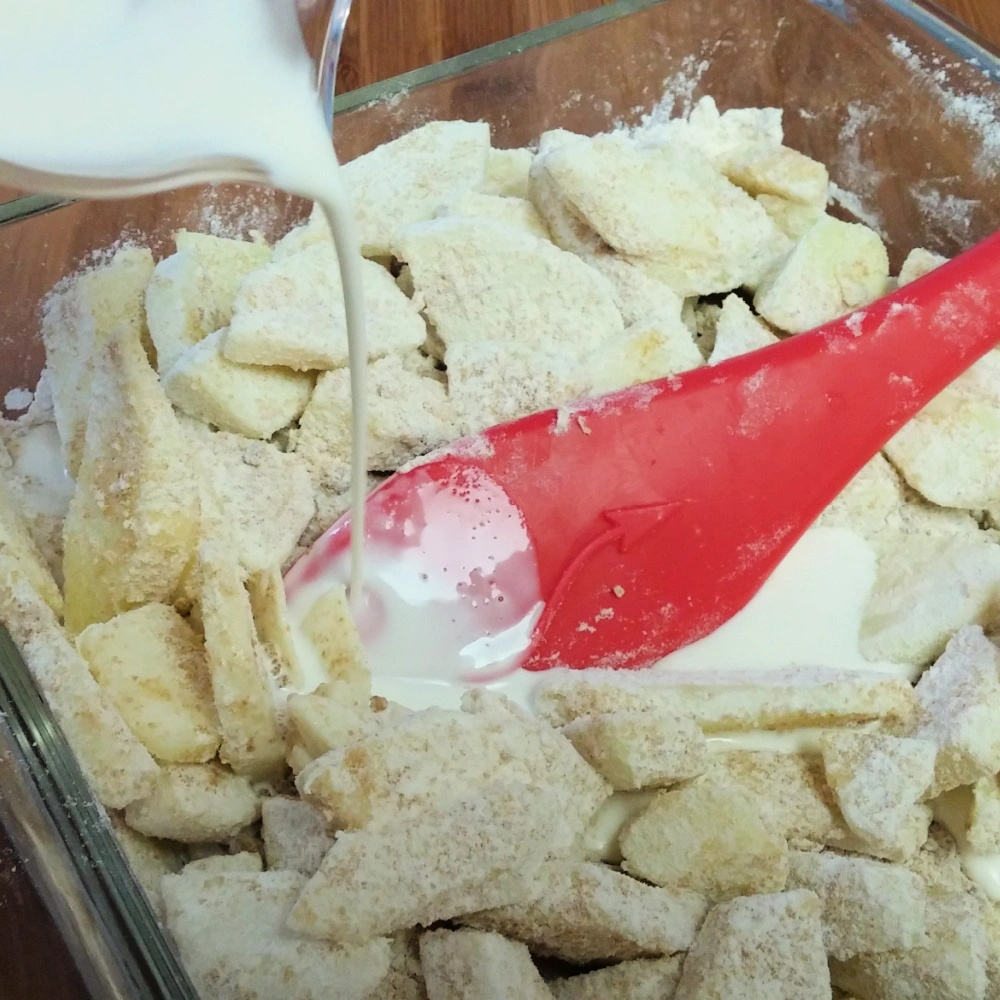 Adding milk to the apple pudding mixture