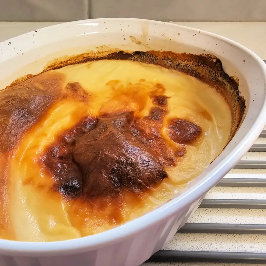 Oven-baked Milchreis in a casserole dish with a browned, crusty top