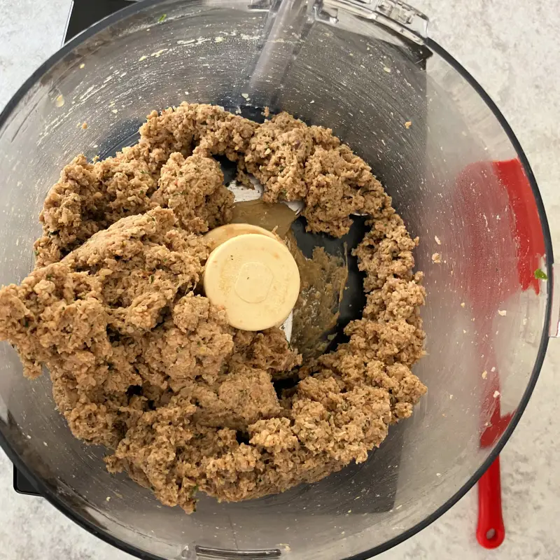 Vital wheat gluten mixed into the lentil mixture in a food processor, forming a seitan dough.
