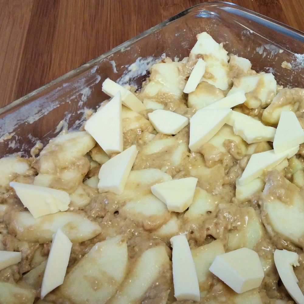 Dotting button on top of apple pudding cake