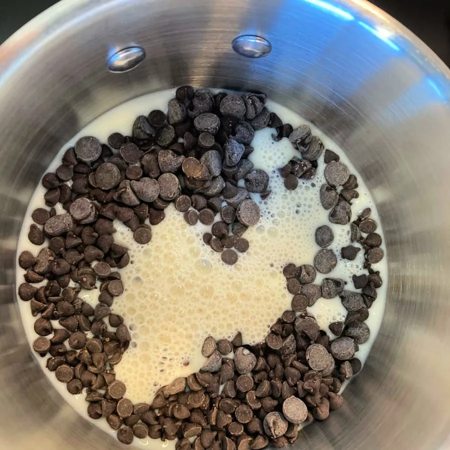Chocolate chips and plant milk in a saucepan for melting into vegan marble cake batter