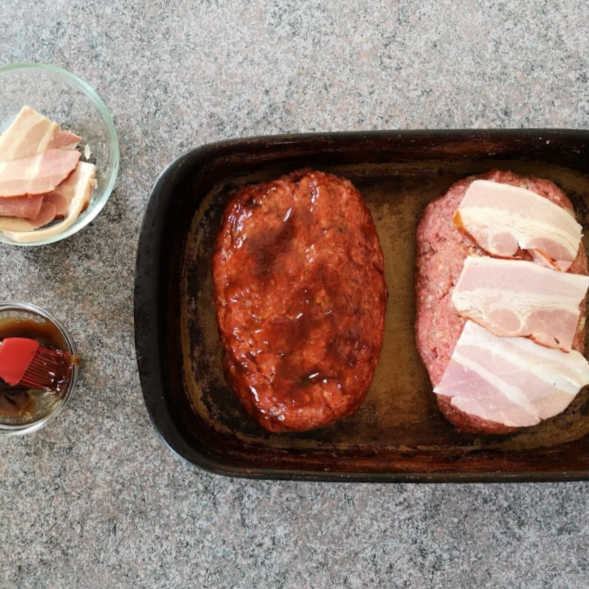 One meatloaf covered with bacon. The other meatloaf brushed with BBQ sauce.