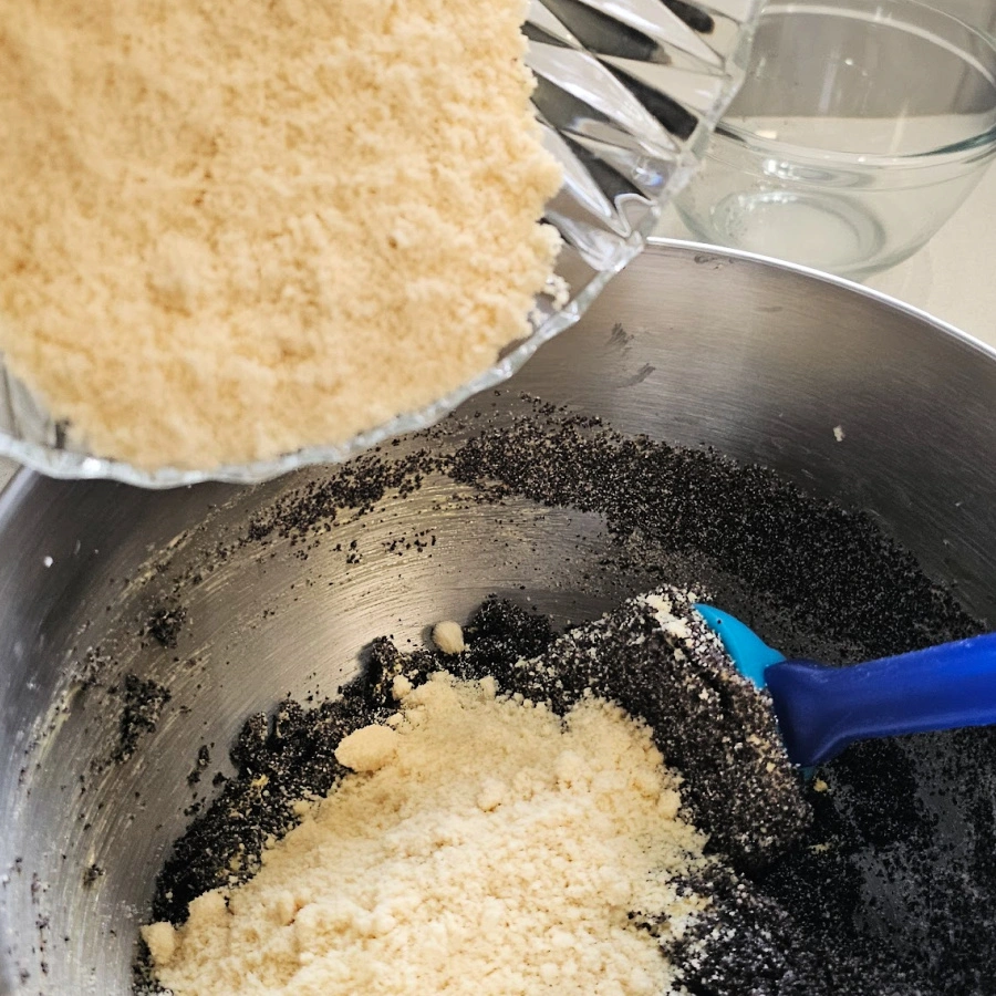 adding nuts and poppy seed to batter for poppy seed cake recipe