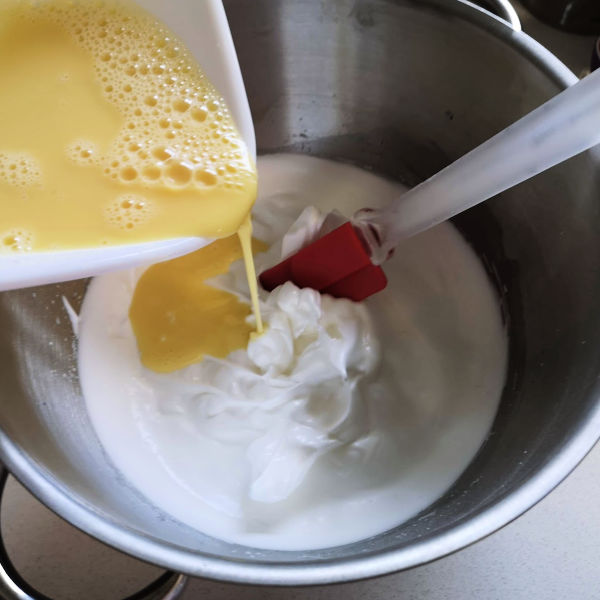 Pour the egg yolk mixture into the whipped egg whites Pour the egg yolk mixture into the whipped egg whites