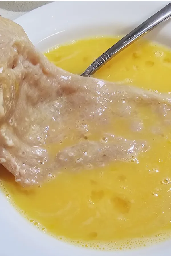 Floured chicken cutlet dipped in beaten egg and milk