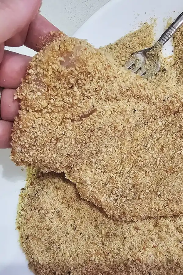Chicken cutlet pressed into fine dry breadcrumbs for German chicken schnitzel