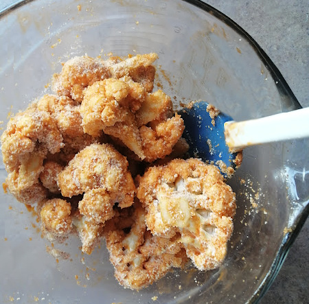Then pour breading and seasoning mixture over sauced cauliflower and mix again, until evenly coated in breading. Then pour breading and seasoning mixture over sauced cauliflower and mix again, until evenly coated in breading.