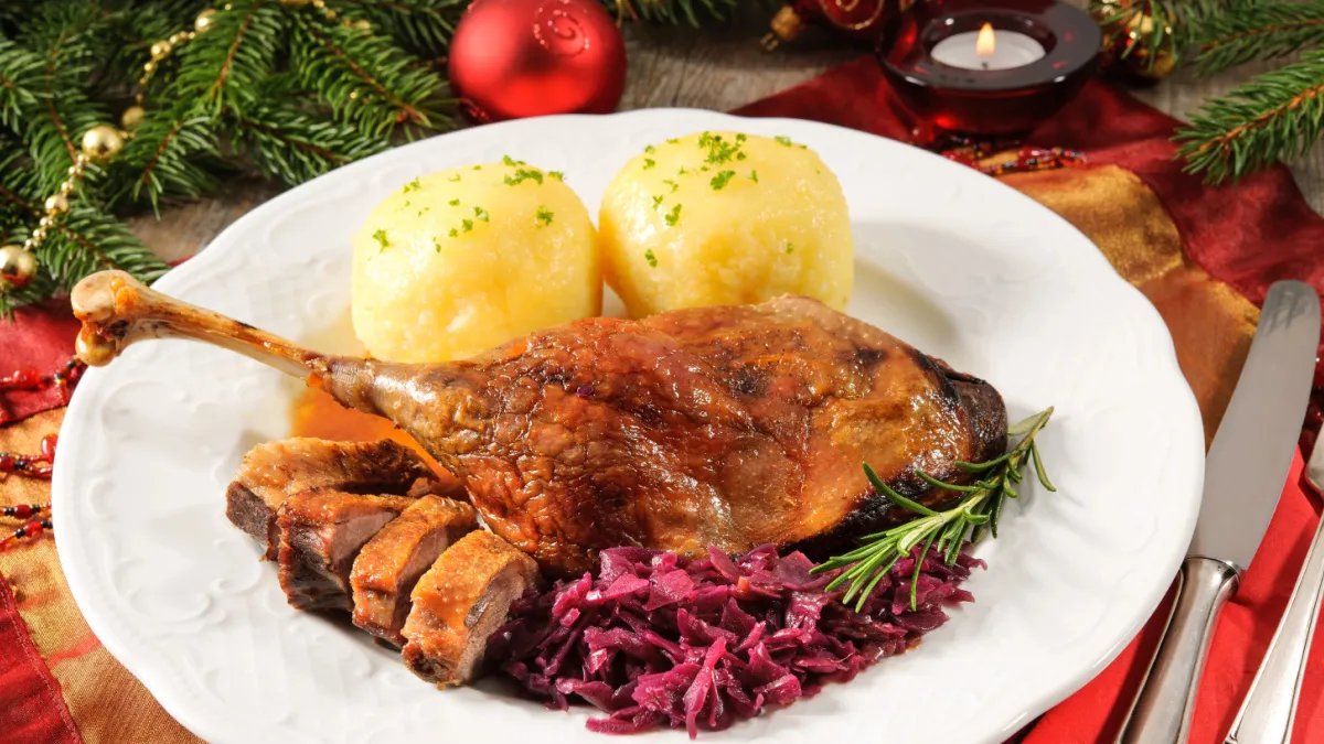 Roast duck leg with German potato dumplings and red cabbage for Christmas dinner.