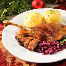 Roast duck leg with German potato dumplings and red cabbage for Christmas dinner.