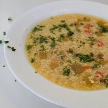German Egg Drop Soup in a white bowl with scattered parsley