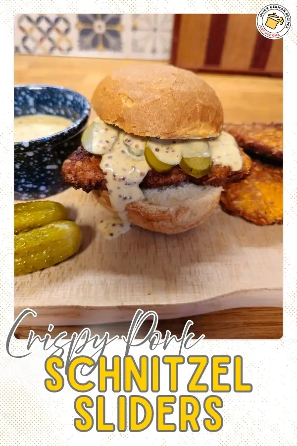 Crispy pork schnitzel sliders on a bun topped with creamy beer mustard sauce and pickles.