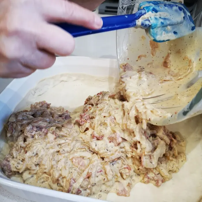 adding zwiebelkuchen filling to pastry adding zwiebelkuchen filling to pastry