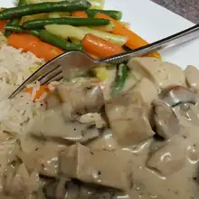 Creamy chicken fricassee with vegetables and rice on a plate