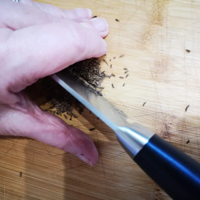 chopping caraway seeds to add to onion tart chopping caraway seeds to add to onion tart