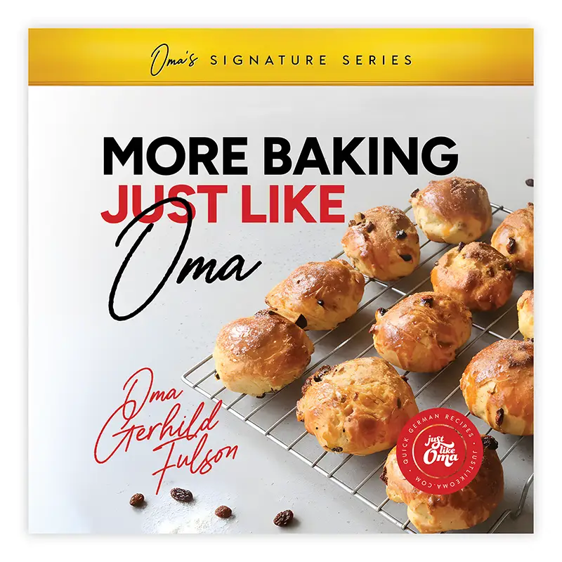More Baking Just Like Oma cookbook cover with golden buns on a cooling rack.