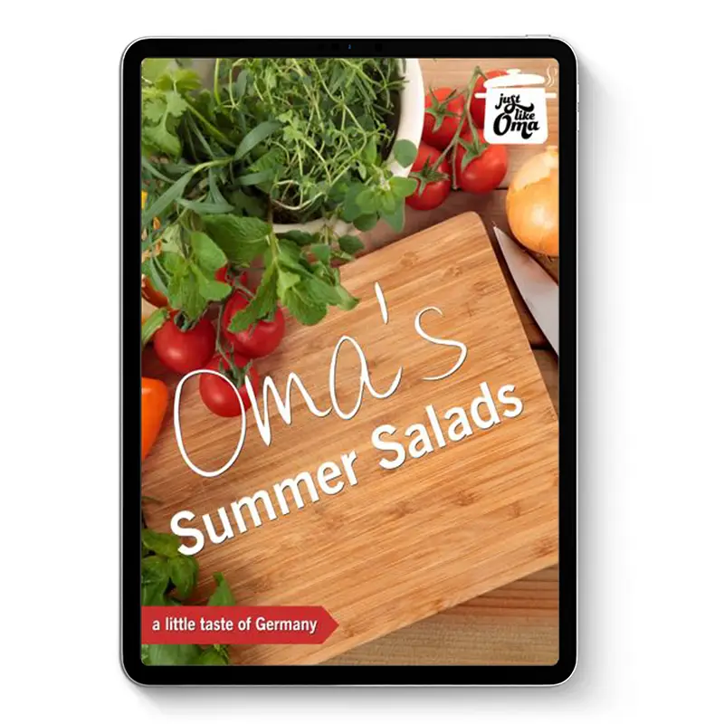 Oma’s Summer Salads ebook cover on tablet with cutting board and fresh tomatoes and herbs on a kitchen counter.