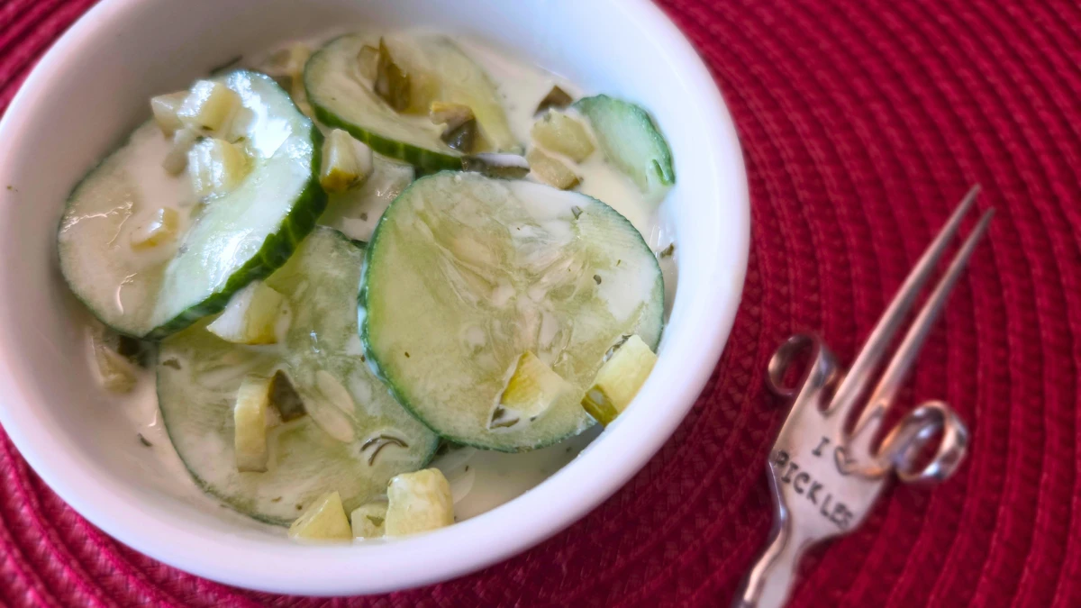 Try this refreshing cucumber dill pickle salad recipe! Cucumber dill pickle salad in white bowl with fork on the side