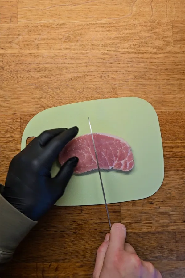 Slicing pork loin Slicing boneless pork to prepare cutlets for homemade pork schnitzel sliders.