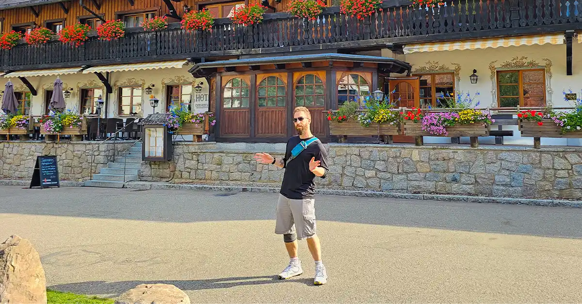 Eran Fulson standing outside a traditional timber-framed guesthouse in the Black Forest, surrounded by flower boxes and Alpine charm.