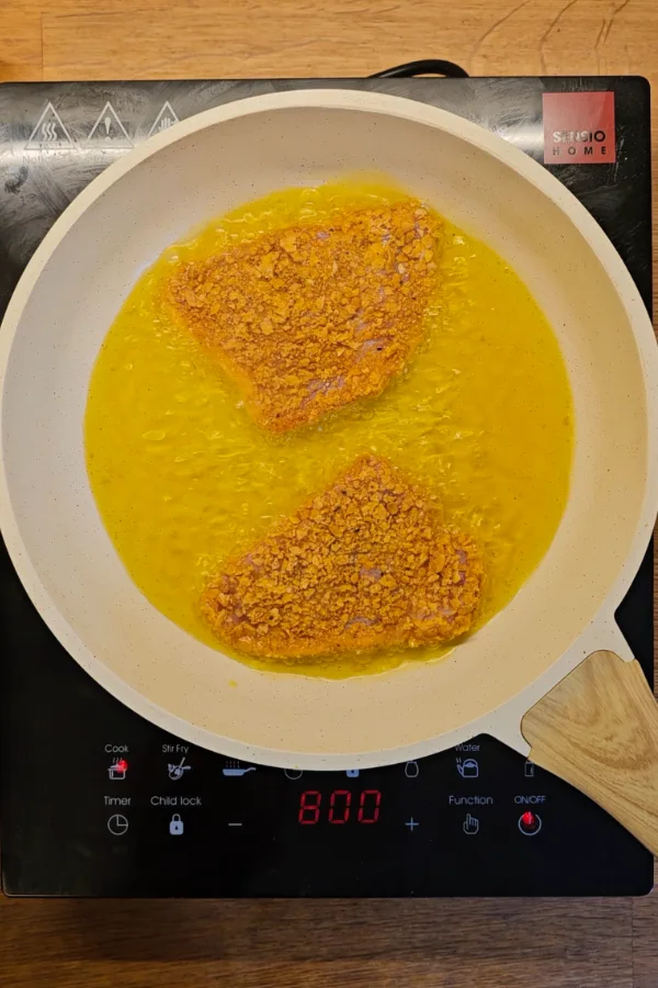 Frying the schnitzel Pork schnitzel frying in hot oil during the preparation of schnitzel sliders.