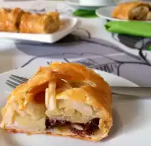 Slice of apple strudel with golden flaky crust and visible filling