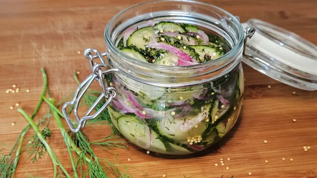 Quick German refrigerator pickles with red onion, dill, and mustard seeds in a glass jar