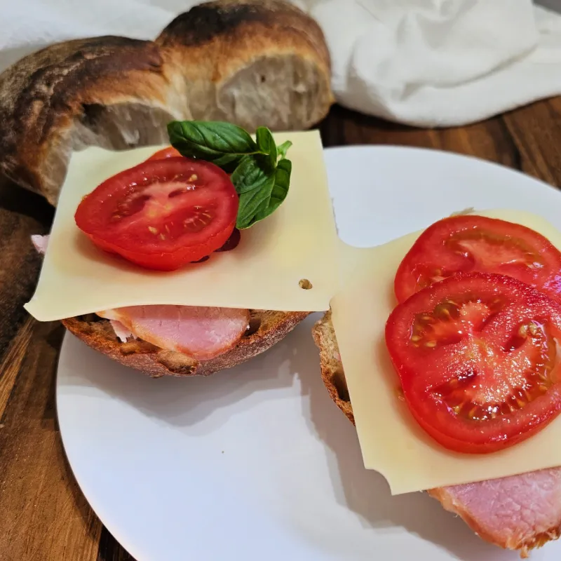 Brötchen topped with ham, cheese, and tomato for Abendbrot
