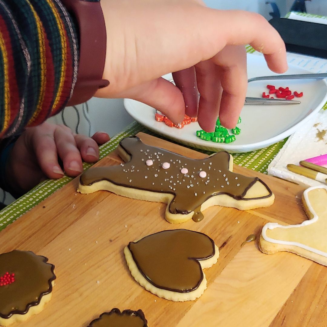 Sprinkling cookies with sugar for a sweet and snowy effect. This works beautifully on the snowflakes! Sprinkling cookies with sugar