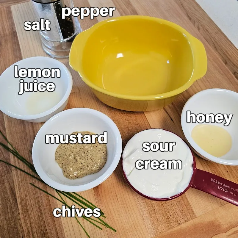 Ingredients for mustard sauce, including sour cream, mustard, honey, lemon juice, chives, salt, and pepper.