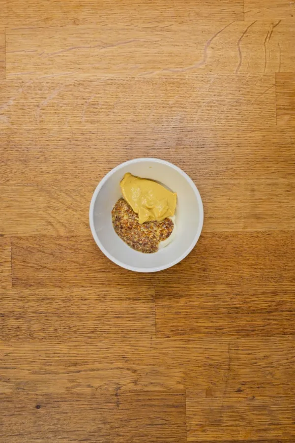 Prepping the beer mustard sauce Whole-grain mustard and dijon mustard in a bowl for the schnitzel slider mustard sauce.
