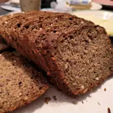 Sliced loaf of hearty German sourdough bread on a plate.
