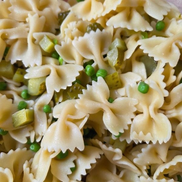 Close-up of dill pickle pasta salad with bowtie pasta diced pickles and peas
