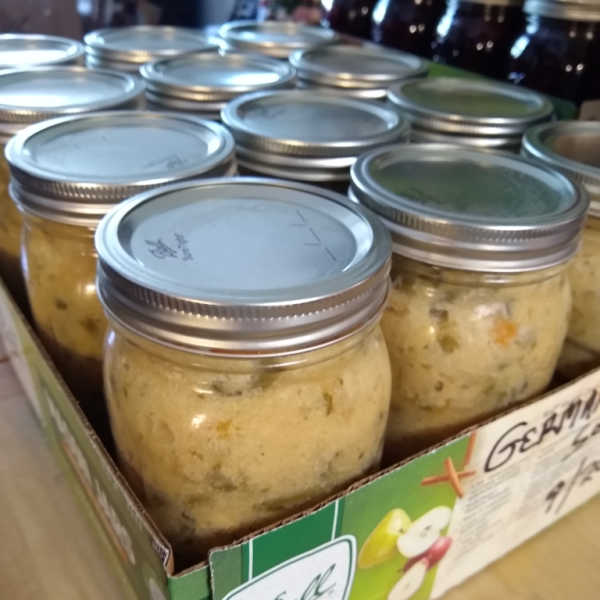Jars of homemade German green bean soup preserved in mason jars and stored in a cardboard tray.