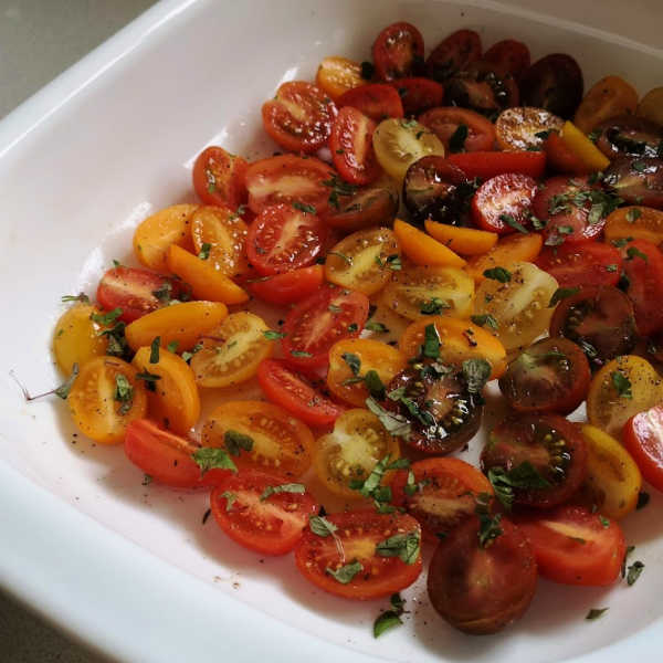 Preparing the cherry tomatoes to be roasted. Here I've cut them in half. It’s perfect for ‘out-of-season’ tomatoes! Preparing the cherry tomatoes to be roasted. Here I've cut them in half. It’s perfect for ‘out-of-season’ tomatoes!